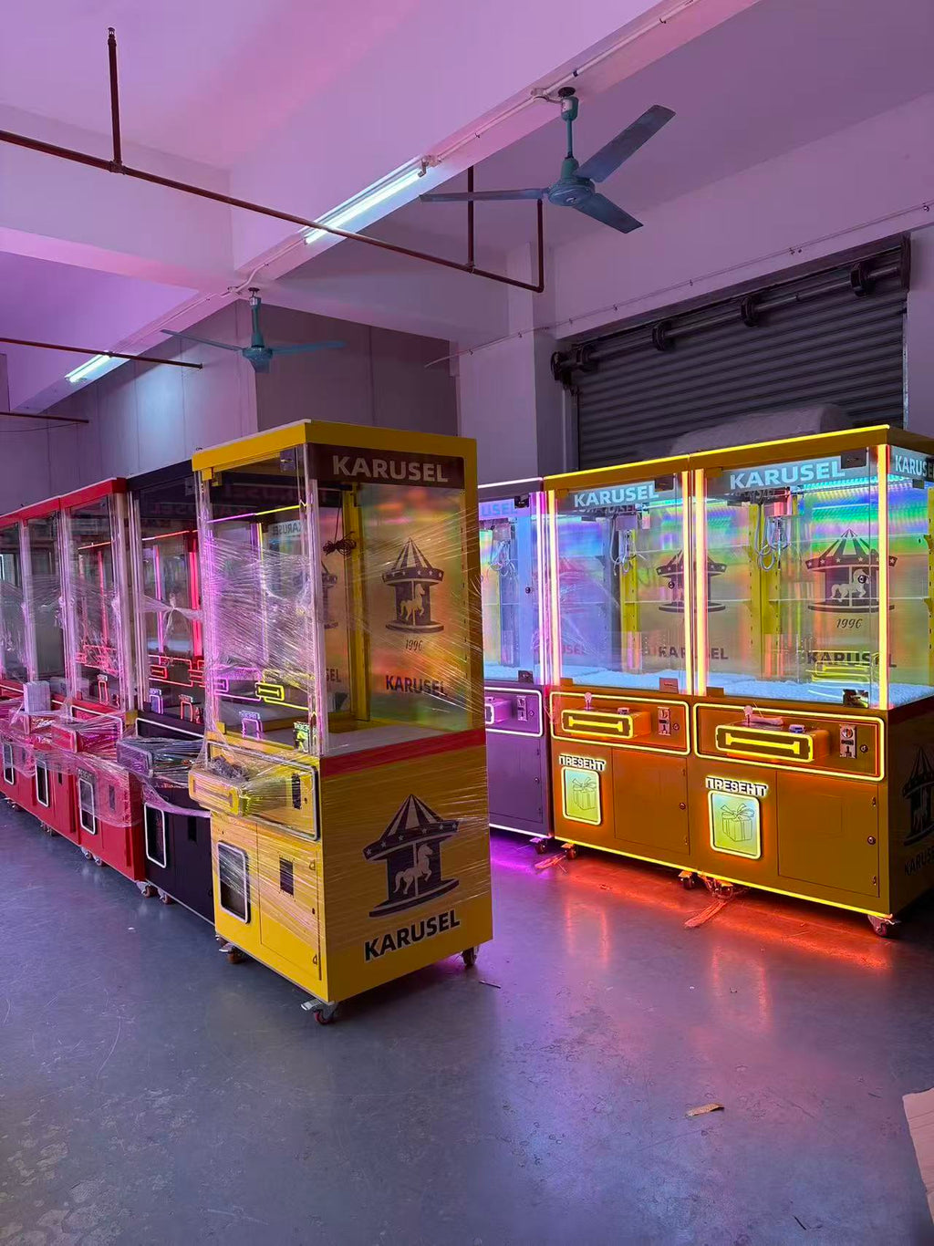 Video game arcade with doll catching machines featuring advertising screens and holding figurines for games and gift dispensers