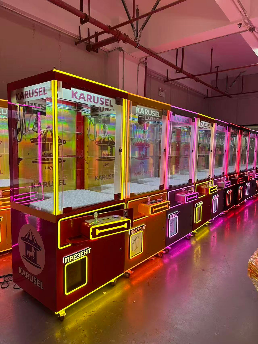 Video game arcade with doll catching machines featuring advertising screens and holding figurines for games and gift dispensers