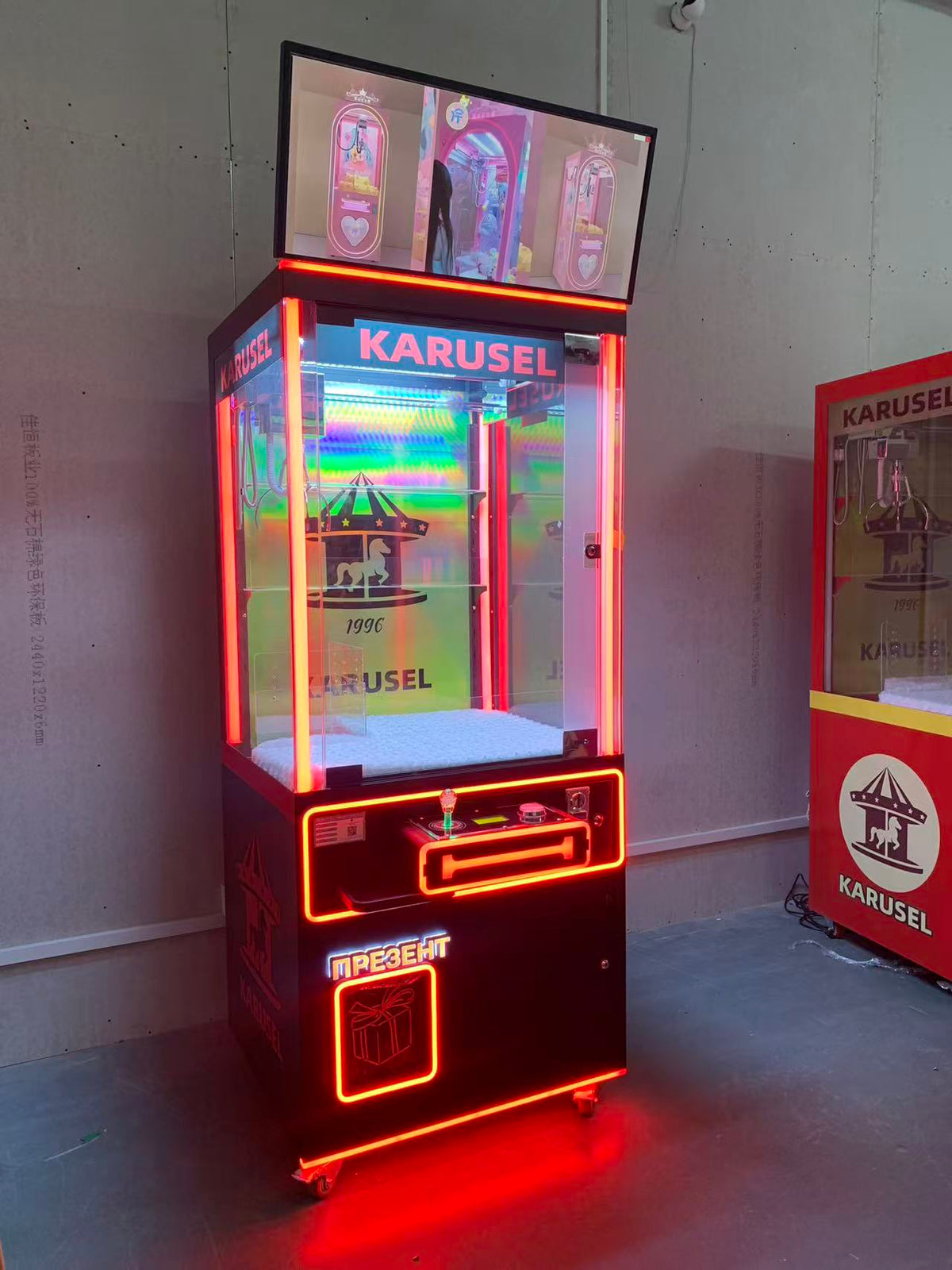 claw machine  with advertising screen featuring collectible figurines and electronic games.