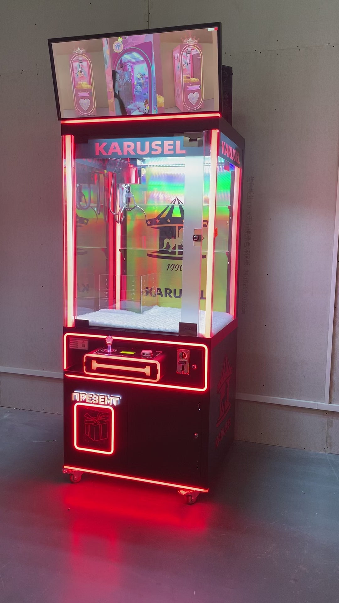 claw machine  with advertising screen featuring collectible figurines and electronic games.